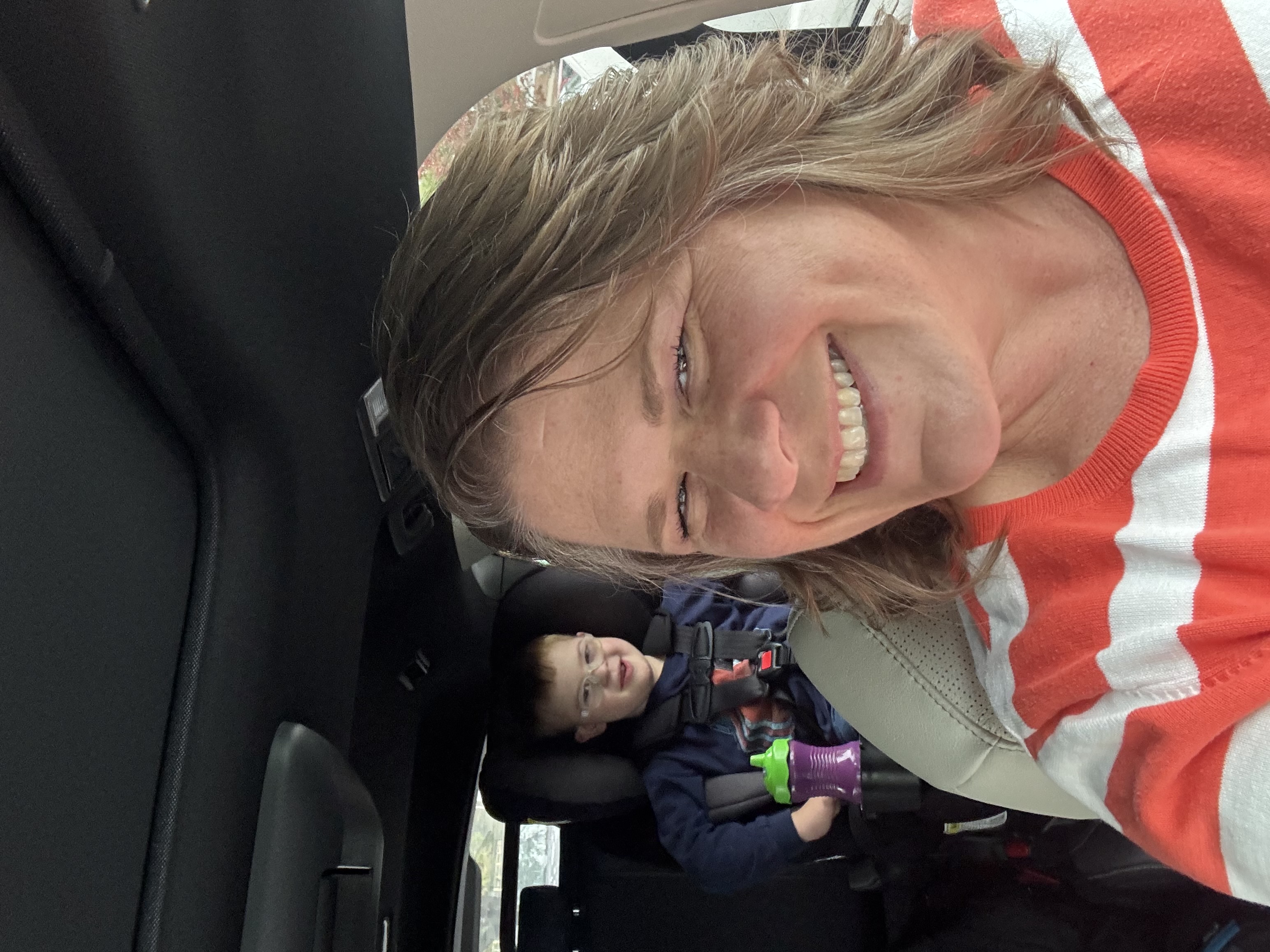 Kristy smiling with Charlie in the backseat